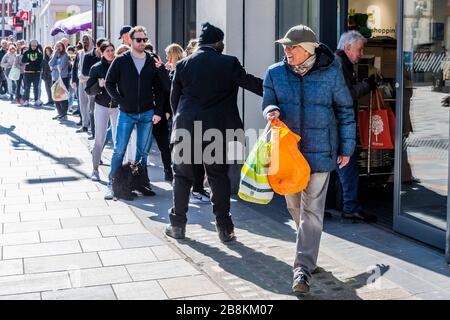 London, UK. 22nd Mar 2020. Grateful workers and pensioners leave with their shopping - Waitrose at Clapham Junction is only open to NHS workers and the over 70's for the first hour so a queue of regular customers waits outside - Anti Coronavirus (Covid 19) outbreak in London. Credit: Guy Bell/Alamy Live News Stock Photo