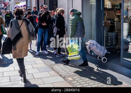 London, UK. 22nd Mar 2020. Some of the queue wear protective masks but there is still little sense that 'social distancing' is vital - Waitrose at Clapham Junction is only open to NHS workers and the over 70's for the first hour so a queue of regular customers waits outside - Anti Coronavirus (Covid 19) outbreak in London. Credit: Guy Bell/Alamy Live News Stock Photo