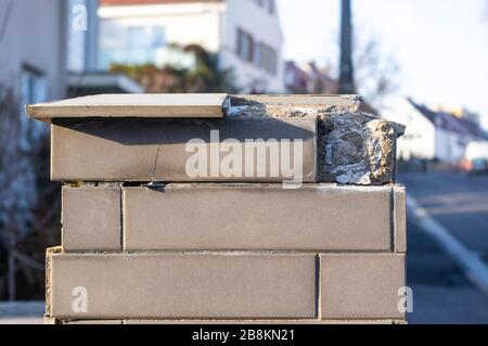 Tiled posts of a garden wall where the tiles fall off due to frost damage Stock Photo