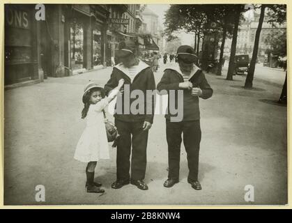 A little girl decorates two sailors, Paris, during World War II Une petite fille décore deux marins. Paris, durant la Première Guerre mondiale. Photographie anonyme, entre 1914 et 1918. Musée Carnavalet, Histoire de Paris Stock Photo