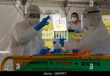 Tel Aviv, Israel. 22nd Mar, 2020. Israeli medical personnel work at the Israeli Magen David Adom national emergency service drive-through complex for COVID-19 testing in the central Israeli city of Tel Aviv on March 22, 2020. The number of the novel coronavirus cases in Israel has risen to 945, the Ministry of Health said Sunday. Credit: Gil Cohen Magen/Xinhua/Alamy Live News Stock Photo