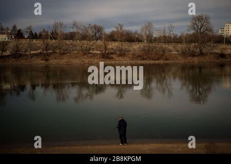 A man fishes at the banks of the Dniester River in Tiraspol city. Transnistria or Pridnestrovie (Pridnestrovian Moldavian Republic) is a de facto state  between Moldova and Ukraine that declared its independence from Moldova  in 1990, resulting in a civil war that lasted until 1992. No UN member state recognizes Pridnestrovie, but it maintains its functional autonomy with military and economic support from Russia. Stock Photo