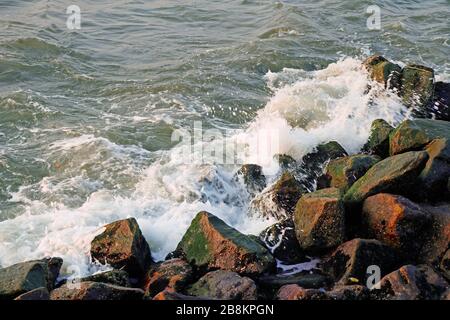 Sea waves hitting rocks on the coast of the sea Stock Photo