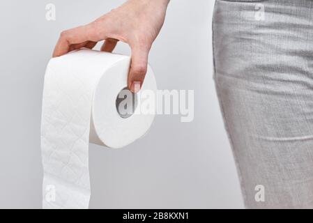 Woman hand hold toilet paper roll, close up. Hygiene concept Stock Photo
