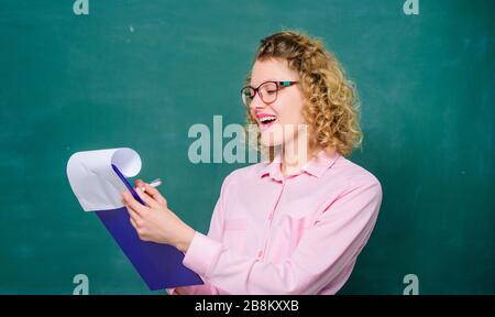 School principal hiring workers. School teacher job position. Read impressing resume. Personal profile. Estimate motivational letters of applicants. School staff. Smart woman hold tablet documents. Stock Photo