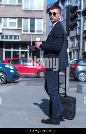 Portrait Of young Businessman  Outside Office. Meeting Concept. Man Walking and drinking coffe, going to the office. Stock Photo