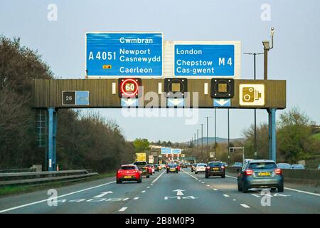 NEWPORT, WALES - NOVEMBER 2019: Traffic on the M4 motorway at Newport at dusk. The gantry carries signs for the variable speed Stock Photo