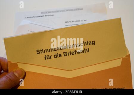 19 March 2020, Bavaria, Munich: ILLUSTRATION - A ballot paper for the runoff election for the mayor's office in the Bavarian capital on 29.03.2020 will be put in an envelope. Photo: Peter Kneffel/dpa Stock Photo