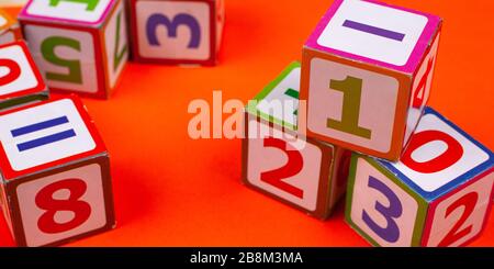 wooden cubes with numbers on an orange background close-up. children’s educational toy. Stock Photo