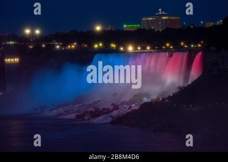 Red white and blue lights at night shining on Niagara Falls Stock Photo