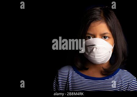 Portrait of little girl wearing a medical mask used for virus protection Stock Photo