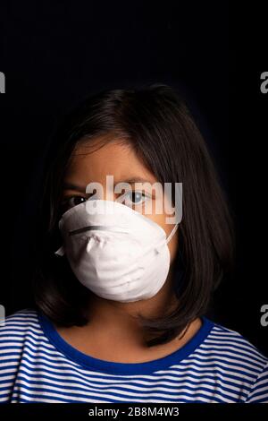 Portrait of little girl wearing a medical mask used for virus protection Stock Photo