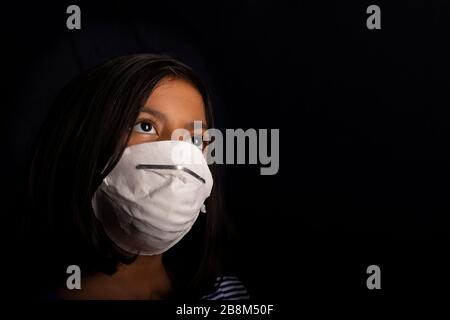 Portrait of little girl wearing a medical mask used for virus protection Stock Photo