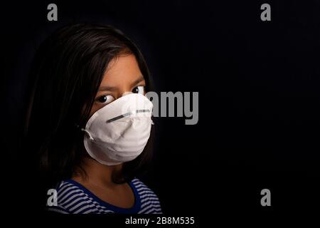 Portrait of little girl wearing a medical mask used for virus protection Stock Photo