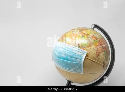 Planet earth weathing a surgery mask, concept of corona virus on white background Stock Photo