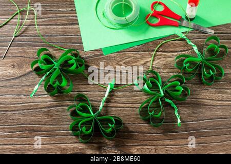 Garland St. Patrick's Day clover, craft from paper. Handmade. Children's art project, needlework, crafts for children. Stock Photo