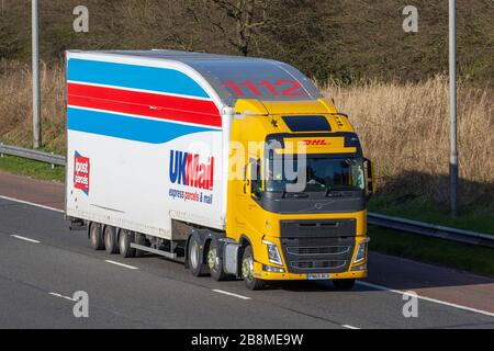 DHL UK Mail Express Parcels; Haulage delivery trucks, lorry, transportation, courier truck, cargo carrier, Volvo FH vehicle, European commercial transport, industry, M61 at Manchester, UK Stock Photo