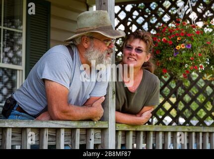 Family farm couple pose on porch Stock Photo