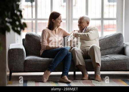 Caring adult daughter talking drinking tea with old father Stock Photo