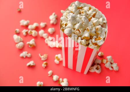 Striped box with popcorn on red background Stock Photo