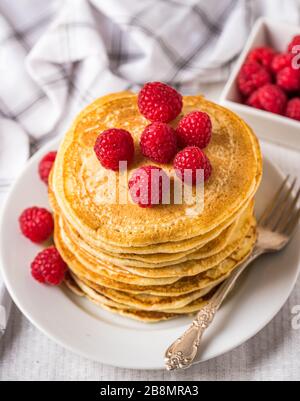 Sweet homemade pancakes with raspberries and on white plate. Stock Photo