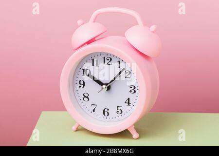 Alarm clock on a pink background, close-up Stock Photo