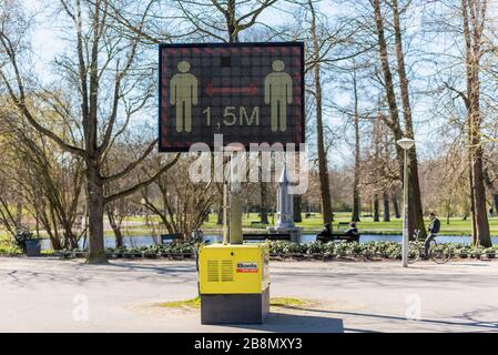 Keep Distance of 1.5 meter Warning Sign on Digital Display in a public park, reminding people of social distancing and avoiding the coronavirus spread Stock Photo