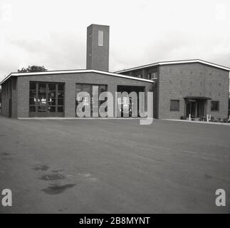 1962, historical, exterior view of a newly built fire station, showing the single level three doored garaging for the fire engines, training tower and the administration building next to it,  England, UK. Stock Photo