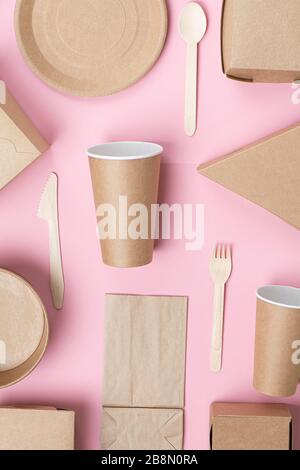 Set of eco-friendly disposable utensils and packaging on a pink background. Stock Photo