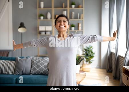 Excited smiling Indian young woman stretching hands, enjoying morning Stock Photo