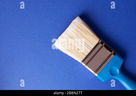 Paint brush on dark blue background, repair concept. Stock Photo