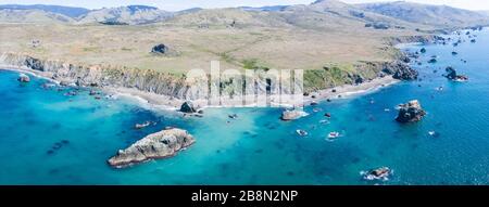 The seemingly peaceful Pacific Ocean washes against the rocky Northern California coastline. This wild area has an inspiringly rugged landscape. Stock Photo