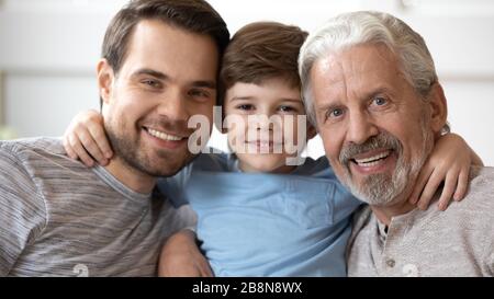 Portrait of happy three generations of men posing at home Stock Photo