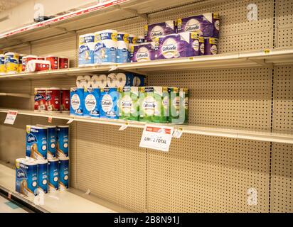 Berks County, Pennsylvania, USA-March 14, 2020: Half empty store shelves with limited supply of toiletpaper Stock Photo