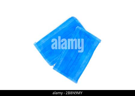 Two light blue surgical mask with rubber straps isolated on a light blue background Stock Photo