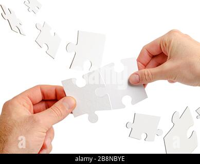 Couple of hands holding jigsaw puzzle isolated on white. Teamwork and business collaboration concept. Stock Photo