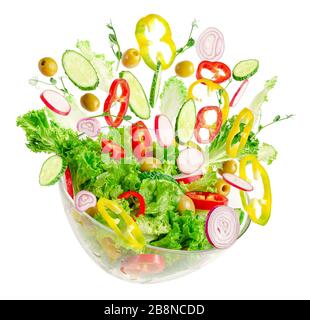 Fresh vegetable salad in transparent bowl with flying ingredients isolated on white. Proper nutrition. Stock Photo