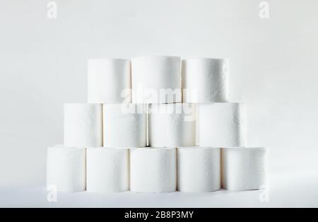 Stacked tower of soft toilet paper rolls on white background. Crisis shortage shop item concept Stock Photo