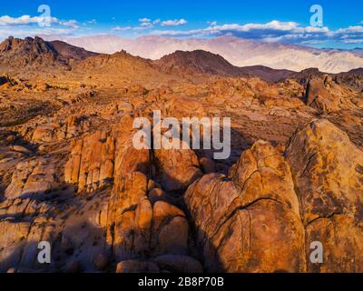 Aerial view of the rock formations of the Alabama Hills with the Inyo Mountains in the distance at sunset. Stock Photo