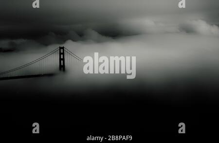 Golden Gate Bridge partially obscured by fog at dusk, San Francisco, California, United States, North America, black and white