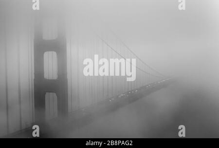 Closeup of Golden Gate Bridge disappearing into the fog, San Francisco, California, United States, North America, black and white Stock Photo