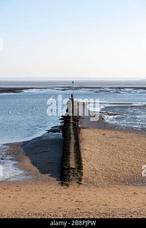 Visitors to Southend-on-Sea, Essex, UK, during the social distancing government guidelines period walking out into the Thames Estuary on a breakwater Stock Photo