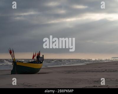 Debki beach, colorful fishing boats at the seashore. Dramatic sky. Baltic Sea, Poland Stock Photo