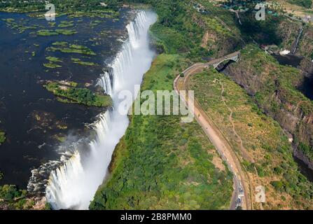 Aerial view of Victoria Falls located between Zimbabwe and Zambia in a sunny day. Water flowing from Zambezi River. Listed by UNESCO as World Heritage