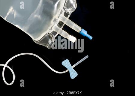 IV bag and blue 10 guage IV catheter on black background. Stock Photo