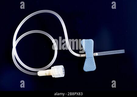 Blue 10 guage IV catheter on dark background. Stock Photo