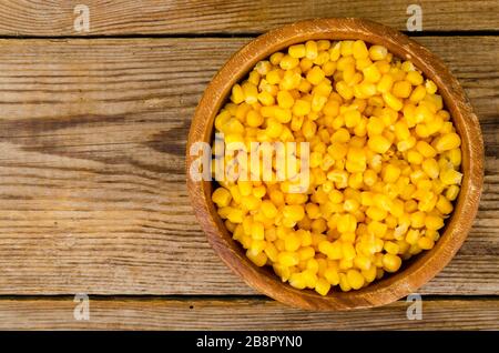 Sweet ripe canned corn in wooden bowl. Studio Photo Stock Photo