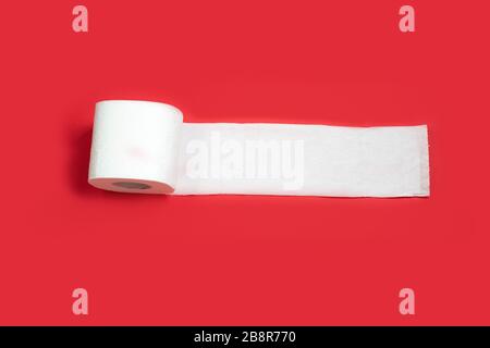 Toilet paper roll on red background. Copy space. Stock Photo