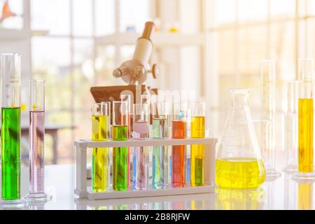 Chemical reagent in scientific experiment flasks of various shapes, sizes and with orange light. Stock Photo