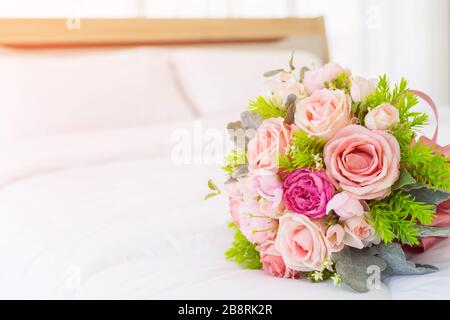 Very beautiful bouquet of flowers laid on a clean white bed. Stock Photo